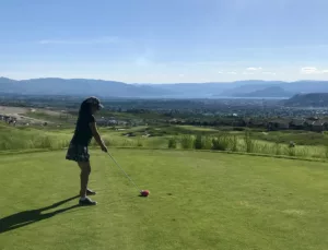 golfer on tee box overlooking city and lake views